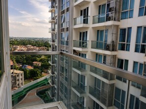 A high-rise building with multiple balconies, large windows, and a view of a residential area below. - Infinity Pool View Near  Mactan Airport & Beach (Lapu-Lapu)