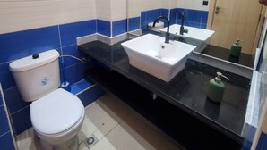 Een badkamer met toilet, wastafel en douche.