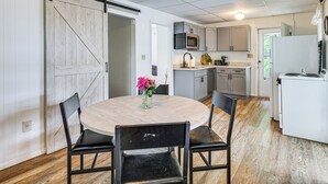 A kitchen with a central island, a sliding barn door, and a dining area with a round table and chairs. - Dock & Sunset Views! Waterfront Thompson Getaway (Thompson)