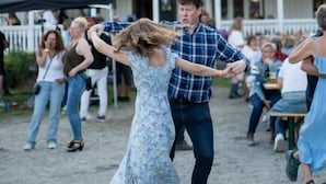 En byggnad med en vit fasad, flera balkonger och en skylt som lyder ”Heartbreak Hotel”.