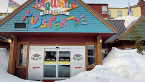 Um edifício com sinalização colorida com os dizeres "Big White Ski Resort" e "Kids Centre".