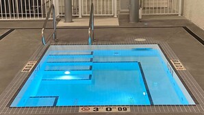 Ein Schwimmbecken mit Bahnen, einem Sprungverbotsschild und einer Tiefenmarkierung von 91 Zentimetern.