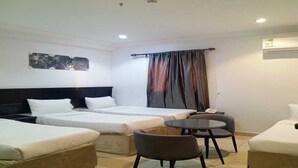 Una habitación de hotel con dos camas, una mesita redonda pequeña y una silla.