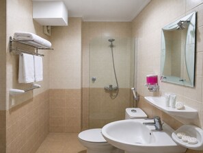 A bathroom with a toilet, sink, shower, and towel rack. - فندق جنة الشعب (Makkah)