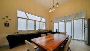 A dining area with a wooden table, chairs, a black tablecloth, and a window with a view.
