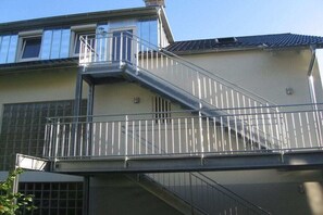 Ein Gebäude mit einer Metalltreppe, die zu einem Balkon, einem Fenster und einer Tür führt.