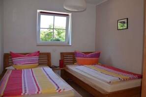 A room with two single beds, a window with a view, and a small picture on the wall. - "Stolzenfels" in the Salzbornhöhe house (Boppard-Weiler)