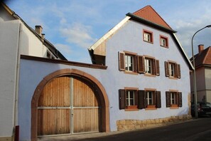 A two-story building with a large wooden door and multiple windows with shutters. - Holiday apartment with 1 bedroom (Edenkoben)