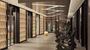 A modern hotel corridor with exercise equipment, large windows, and a minimalist design. - AC Hotel Bulle (Bulle)