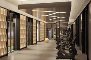 Un pasillo de hotel moderno con equipo de ejercicio, ventanas amplias y un diseño minimalista.