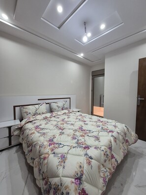 A modern bedroom with a bed, nightstands, a mirror, and a door. - Lovely 2-bedrooms apartment in pleasant Saidia (Saidia)