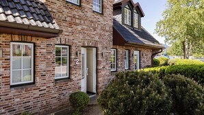 A brick house with a tiled roof, a door, and a window. - Beach Love Sylt - Westerland (Westerland)
