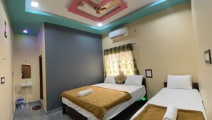 Una habitación de hotel con dos camas, un baño y un techo con diseños geométricos.
