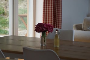 Ein Holztisch mit einer Blumenvase und einer Flasche.