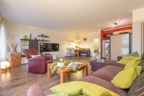 Ein Wohnzimmer mit einer Couch, einem Couchtisch und einem Essbereich mit Tisch und Stühlen.
