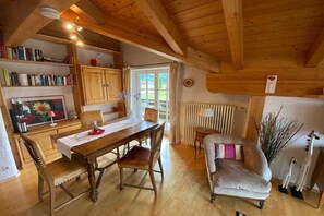 Ein Holzinterieur mit Esstisch, Stühlen, einer Couch und einer Heizung.