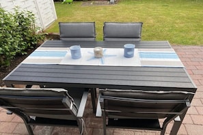Ein Patio-Tisch mit zwei Stühlen, einer Meeressterne als Dekoration und zwei Kerzen.