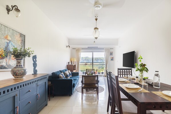 A modern living room with a sofa, dining table, and decorative items.