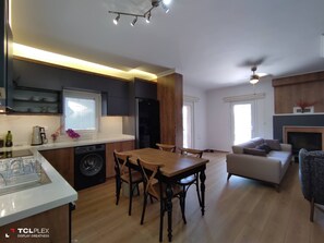 A modern kitchen with a dining area, a washing machine, and a sofa in a living room. - Beautiful House In Fethiye (Fethiye)