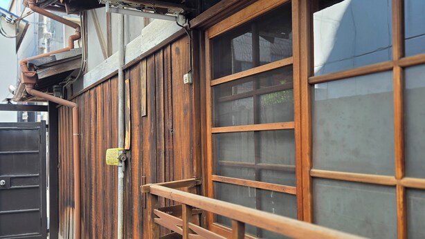 Una construcción de madera con una puerta corredera y una verja de metal.