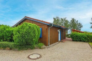 A single-story building with a sloped roof, a blue door, and a gravel driveway. - Maribell - House Type II (Jabel)