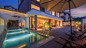 Una piscina al aire libre de temporada, sombrillas