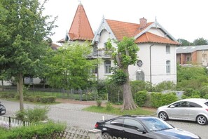 Ein Gebäude im traditionellen Baustil, mit einem markanten Turm und einem roten Ziegeldach.