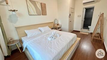Habitación de hotel con cama, mesita de noche, espejo y una escalera de madera.