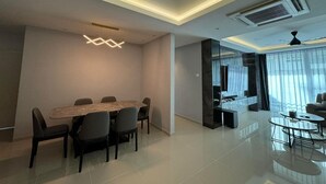 Una sala de estar moderna con comedor, ventanas amplias y ventilador de techo.