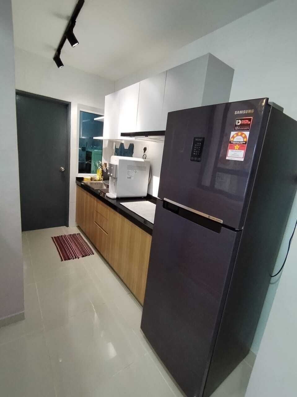 A modern kitchen with a black refrigerator, a coffee maker, and a microwave.
