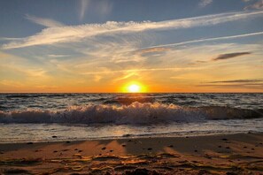 A sunset over the ocean with waves on the shore. - Holiday apartment with 1 bedroom (Ostseeheilbad Zingst)