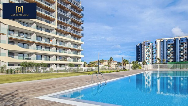 Un hôtel moderne doté d’une piscine, de nombreux balcons et d’un espace extérieur bien entretenu.