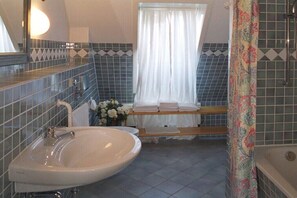 Ein Badezimmer mit Waschbecken, Spiegel und Duschvorhang.
