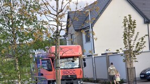 Ein roter SDCC-LKW parkt in einer Wohnstraße.