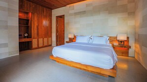 A bedroom with a wooden bed frame, two bedside tables with lamps, and a wooden wardrobe.
