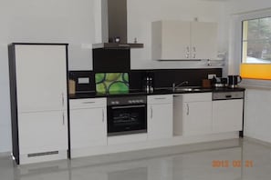 Een koffiezetapparaat/waterkoker, een koelkast, een oven, een kookplaat
