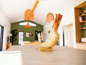 A modern interior with a unique boat-shaped sculpture on a marble table, wooden shelves, and hanging wicker lamps. - Villa between the Landes forests and ocean (Seignosse)