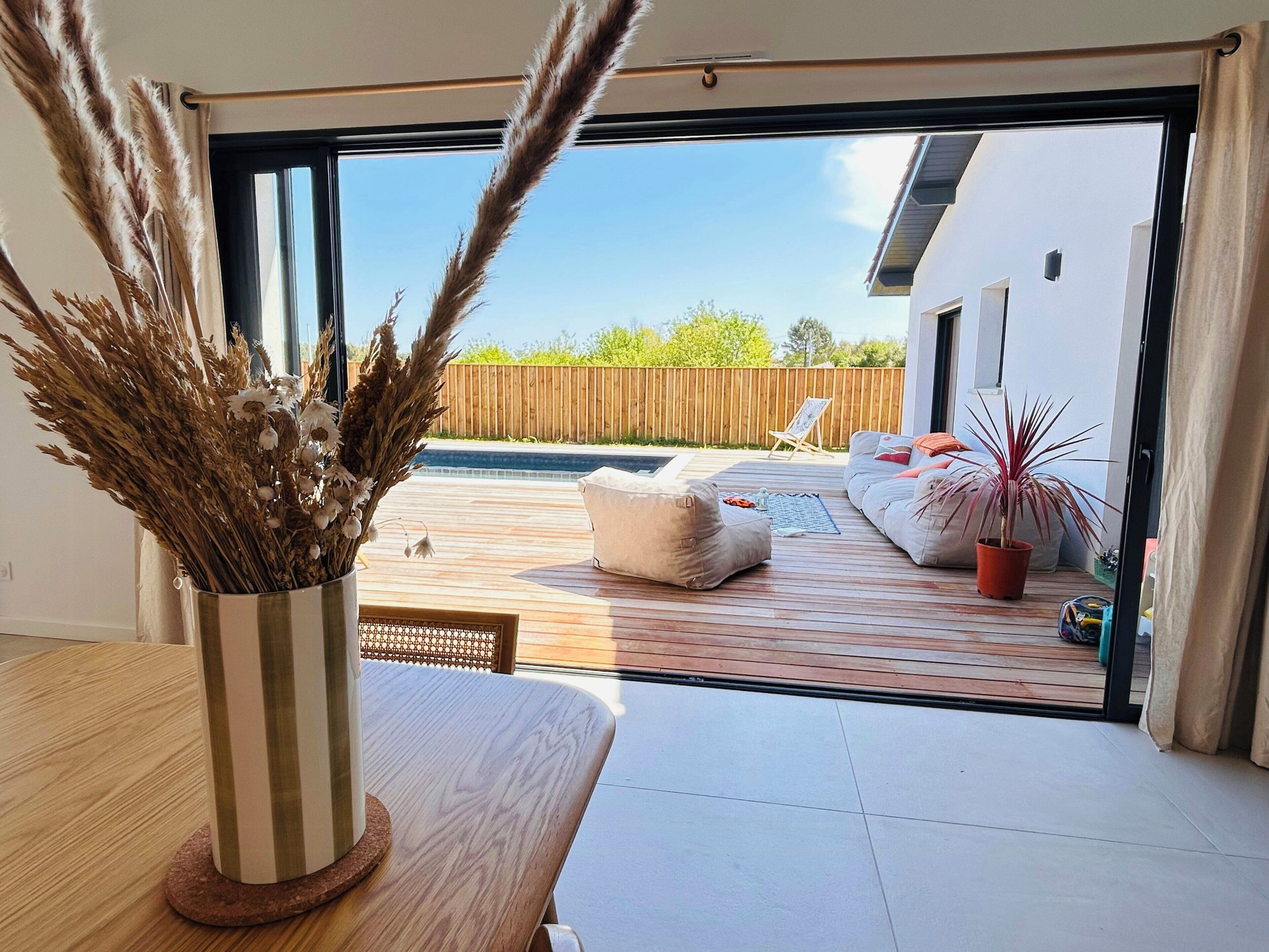 A modern living room with a large sliding glass door leading to an outdoor patio area.