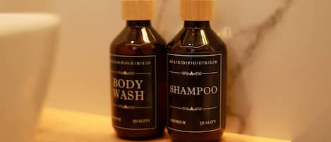 Dois frascos de gel de banho e shampoo sobre uma superfície de madeira.