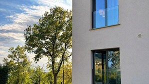 Ein modernes, zweistöckiges Gebäude mit großen Fenstern und einem gepflegten Rasen.