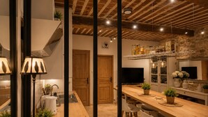A modern kitchen with a wooden countertop, white chairs, and a TV. - 16624498LIONS Le Suquet Old Town Forville Cozy Apartment (Cannes)