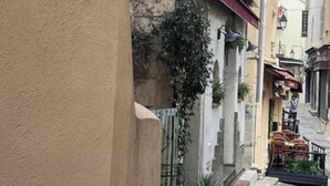 A narrow street with buildings on either side, some with balconies and plants. - 16514416 LIONS La Croisette, just a stone's throw away (Cannes)