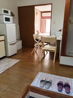 A compact kitchen with a refrigerator, microwave, and a small table with chairs.