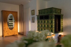 Um quarto com uma porta de madeira, um armário com azulejos verdes e um espelho.