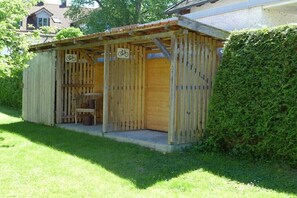 Een houten constructie met een fietssymbool, wat aangeeft dat het een fietsenstalling is.