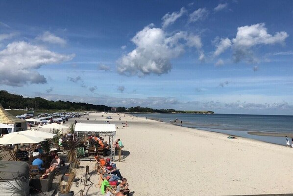 A beach with umbrellas and chairs, a sandy shore, and a clear sky. - Villa Sonnengarten 7 (Boltenhagen)