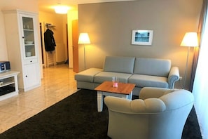 A living room with a sofa, a coffee table, a cabinet, and two lamps. - Villa Sonnengarten 7 (Boltenhagen)