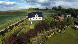 Ein Haus mit großem Garten, umgeben von Feldern und Bäumen.