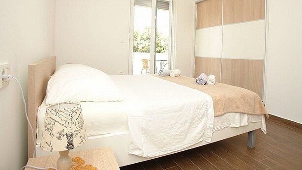 Un dormitorio con cama, mesita de noche y ventana con vistas.