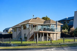 Een tweelaags huis met een overdekte veranda en een zichtbare trap.